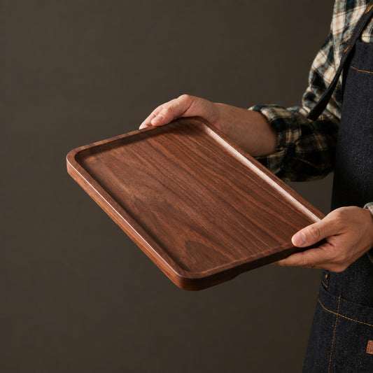 Person holding a wooden tray with text on a dark background